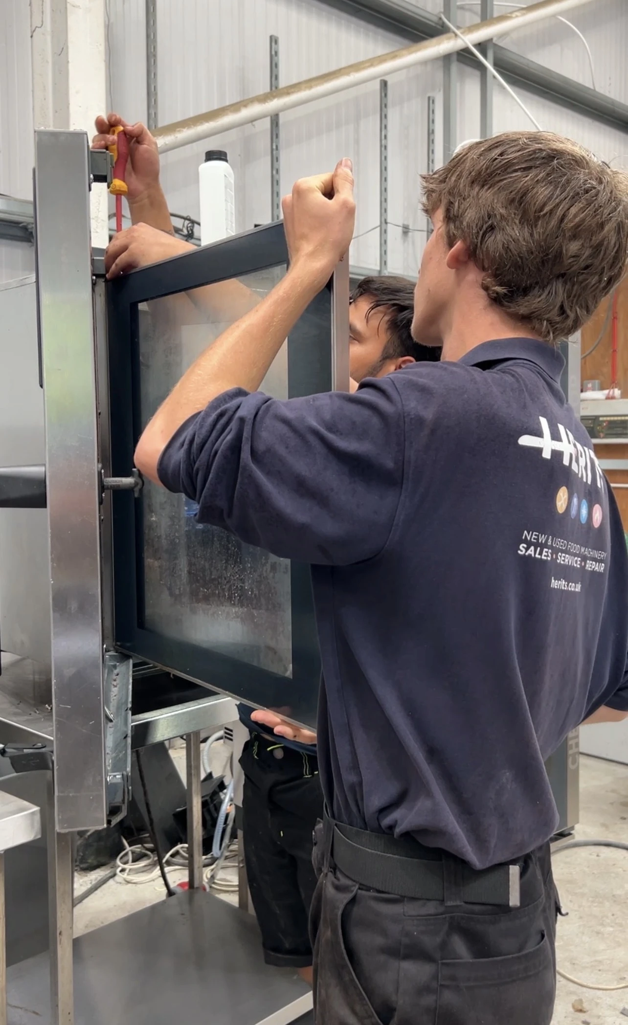HERITS team member inspecting catering equipment in the workshop