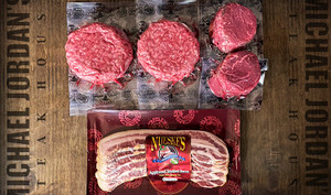 Pictured is 2 Linz Heritage Angus filets, 4 Linz steakburgers, and Nueske's Triple Cut Bacon in packaging on a cutting board.