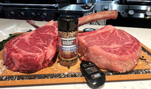 Pictured are 2 uncooked images of 40 oz tomahawks with Weber Grill seasoning and a digital thermometer.