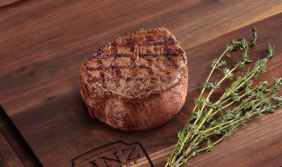 Pictured is a cooked Tenderloin Filets Linz Heritage Angus Reserve on cutting board with Thyme