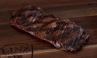 Pictured is a cooked whole Linz Heritage Angus reserve skirt steak on a cutting board.