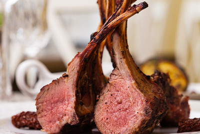 Pictured is a cooked rack of lamb on a plate