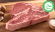 Pictured is an uncooked USDA Prime Halal porterhouse on a cutting board.