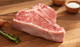 Pictured is an uncooked Linz Heritage Angus USDA Prime porterhouse on a cutting board