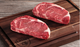 Pictured are 2 uncooked Linz Heritage Angus reserve boneless double cut ribeyes on a cutting board