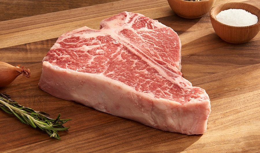 Pictured is an uncooked Linz Heritage Angus USDA Prime porterhouse on a cutting board