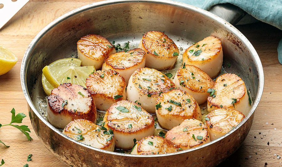 Pictured is a pan full of cooked scallops