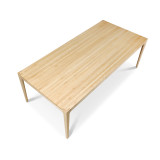 An angled perspective of the solid maple dining table, highlighting the continuous, linear variations of the edge grain butcher block surface and the elegant downward taper of the solid wood legs.