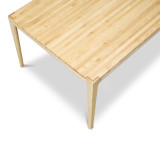 An elevated perspective over the short side of the solid maple Parsons dining table, revealing the continuous edge grain butcher block surface and the clean architectural lines of the tapered legs.