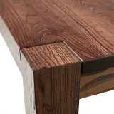 Close-up of Signature Parsons Dining Table corner showing solid ash grain, flush leg top cap, refined edge detail, and seamless joinery