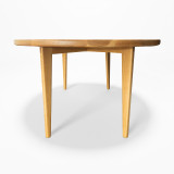 Low angle view of the Horizon Dining Table with sculpted white oak edge, tapered legs, and refined hardwood base
