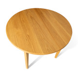 Overhead view of the Cascade Round Dining Table showing natural hardwood grain, round top, and clean modern silhouette