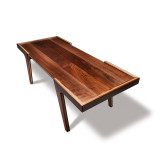 Angled overhead view of solid walnut modern coffee table with floating tabletop, clean lines, and maple accent lamination