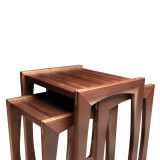 Angled overhead view of modern walnut nesting tables showing three-table configuration, natural grain, and architectural design