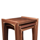 Close-up of nested walnut tables with solid wood construction, rich grain variation, and contrasting maple spline details
