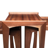 Front detail of modern walnut nesting tables highlighting butcher block walnut tops, mitered legs, and maple spline accents