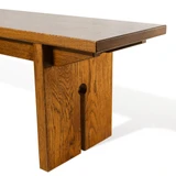 Corner detail of the white oak keyhole bench showing the seat edge, angled leg bracket, and keyhole opening