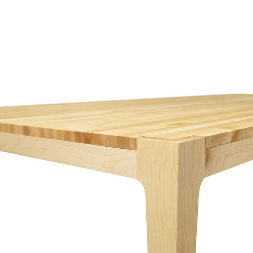 A lower-angle shot of the modern Parsons table emphasizing the sturdy, universally designed solid maple understructure that provides full, unobtrusive ADA-compliant accessibility.