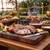 A steaming hot carved suckling pig sits on a beautiful walnut end grain butcher block cutting board from Hardwood Lumber Company at a luxury resort luau.
