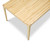 An elevated perspective over the short side of the solid maple Parsons dining table, revealing the continuous edge grain butcher block surface and the clean architectural lines of the tapered legs.