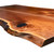 Low-angle perspective from the upper right of a Black Walnut book matched countertop, highlighting a natural knot stabilized with black-pigmented structural epoxy and the wandering, organic line of the live edge profile.