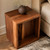 Walnut rift live edge side table from HLC Furniture styled as a nightstand beside a bed with a ceramic vase and dried flowers