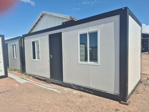 BasePod 10™ modular unit on-site in Townsville, featuring black framing, light grey panels, and two front-facing windows.