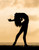 Silhouette of a female dancer one leg outstretched and leaning backwards on a sepia background