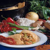 Mrs Wheat's Crawfish Pies 12ct 3.5oz, freshly baked crawfish pies sliced open on a plate showing tender crawfish filling inside, surrounded by fresh vegetables and ingredients.