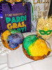 Creole Foods of Louisiana Mini King Cake Date Night, colorful mini king cakes with vibrant icing and glitter, Mardi Gras decorations, and themed shopping bags.