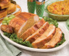 Broussard's Bayou Broussards Bayou Company Stuffed Chicken with Cornbread Dressing 3lb, cooked stuffed chicken breast sliced and served on a platter with greens, grapes, and side dishes in the background.