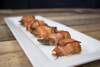 Broussard's Bayou Broussards Bayou Company Boudin Stuffed Jalapenos 6ct, close-up of baked jalapenos wrapped in bacon on a white rectangular plate.