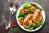 Ragin Cajun 8oz Chicken or Gator Cajun Seasoning & Rub, grilled chicken served with fresh vegetable salad on a white plate.