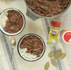 Louisiana Fish Fry Trinity Shake 4.1oz, seasoning blend container and prepared beef stew with rice in bowls on a table.