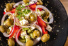 Central Grocery’s Original & Hot Olive Salad Combo 16oz – Authentic New Orleans Taste, close-up of a fresh olive salad with green olives, red and green peppers, red onion slices, and cheese on a black plate.