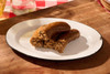 The Best Stop Original Boudin 14oz, cooked sausage boudin with visible chopped meat and rice filling on a white oval plate