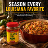 Slap Ya Mama Original Blend Cajun Seasoning 32oz, a jar of spicy Cajun seasoning placed next to a colorful pot of Cajun cuisine with seafood, sausage, and vegetables, surrounded by garlic, onion, green bell pepper, and herbs on a wooden table.