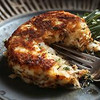 Carnival Premium 65% Lump Crab Cakes, close-up of a cooked crab cake on a fork showing crispy golden crust and tender crab filling