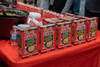 Ragin Cajun Authentic Seafood Bisque 5oz, multiple boxes of the seafood bisque product displayed on a table at a food market.