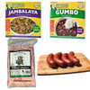Gator Gumbalaya Bundle by Jambalaya Girl, including seasoned rice blend, gumbo base mix, smoked sausage, and fresh aligator fillet on a wooden cutting board.