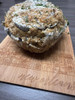 Sal's Riverside Seafood Sal's Stuffed Artichoke, a baked artichoke filled with seafood stuffing and topped with cheese, placed on a wooden serving board.