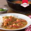 Louisiana Fish Fry Cajun Etouffee Base 2.5oz, image shows a plate of shrimp etouffee with rice garnished with green onions, with a bowl of greens in the background.