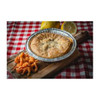 La Boucherie Crawfish Pie, 0.75 lb, served in a pie dish on a wooden board with lemon and fried crawfish on the side, on a red and white checkered tablecloth.