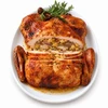 Cornbread Turducken 10lbs, cooked turducken served on a white platter garnished with herbs and vegetables, ready to serve approximately 15 people.