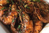 Louisiana Fish Fry BBQ Shrimp Mix 1.5oz, cooked shrimp garnished with herbs in a close-up view.