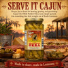 Cajun Chef Mild Pickled Okra 12oz, jar of pickled okra immersed in brine with yellow mustard seeds visible, surrounded by cheese, olives, meats, and bread on a rustic wooden surface during a sunset outdoor setting.