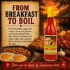 Cajun Chef Louisiana Hot Sauce 12oz, red hot sauce bottle with yellow cap and label, surrounded by Louisiana foods like crawfish, corn, and seafood, with a sunset and river background.