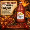 Cajun Chef Louisiana Hot Sauce 128oz, bottle of hot sauce with a rustic Louisiana-themed background of crawfish, corn, and garlic on a wooden table.