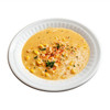 King Creole Corn & Crab Bisque 4lb, creamy and flavorful seafood and corn soup garnished with herbs and spices in a white bowl.