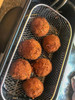 Comeaux's Seafood Balls 1lb, crispy golden fried seafood balls on a wire rack in a metal basket.